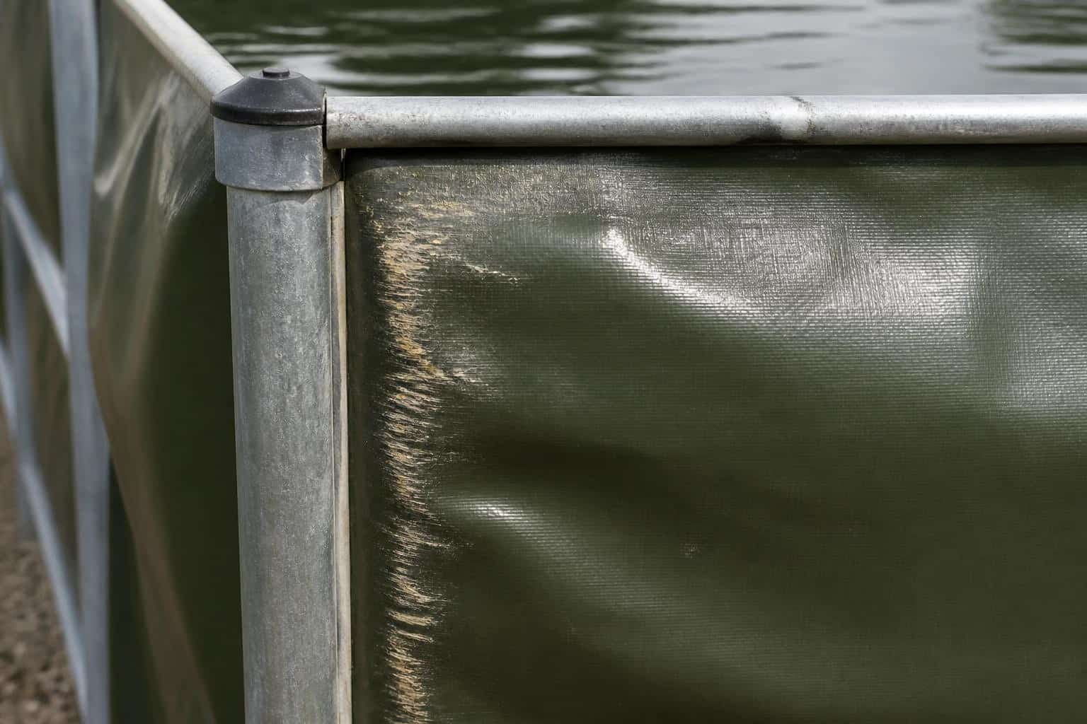 Frame tank liner abrasion where the coated fabric presses against the steel frame corner and rail